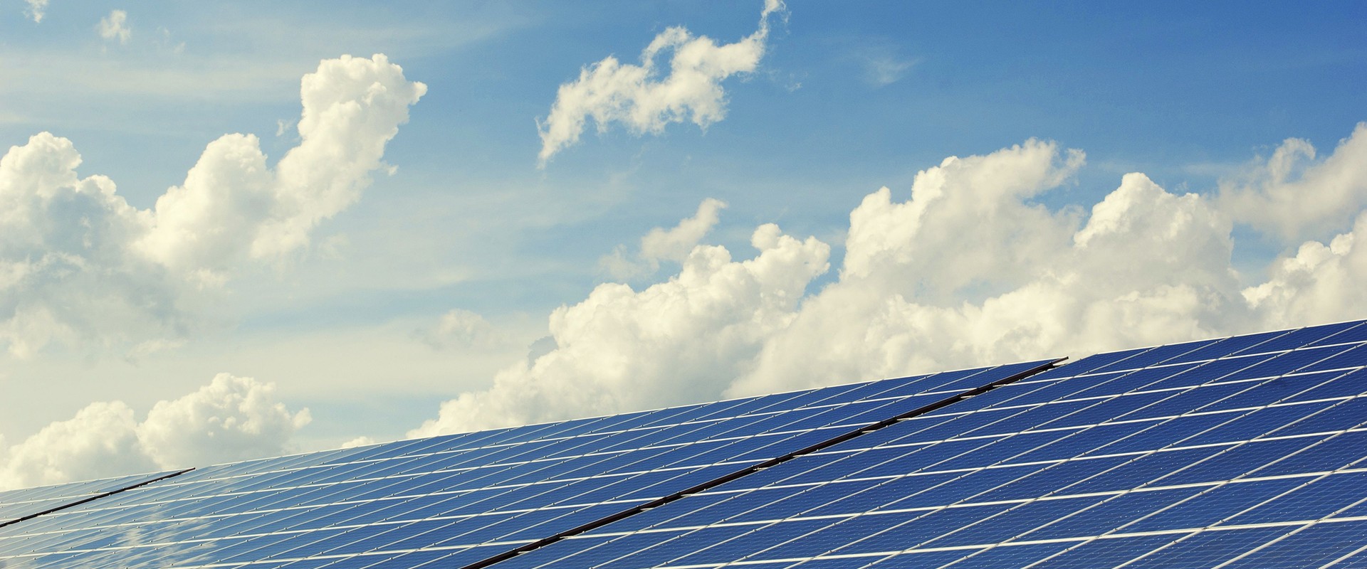 Impianto fotovoltaico con pannelli solari sotto un cielo nuvoloso